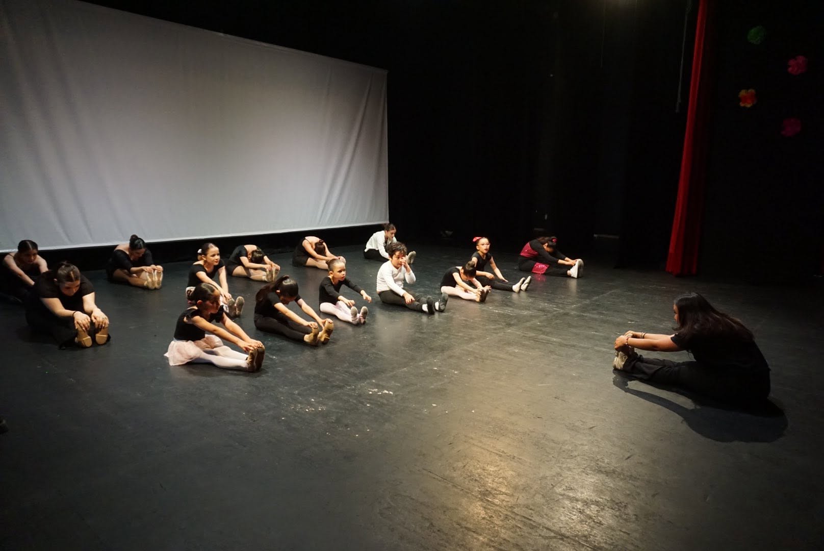 Instructora trabajando con bailarinas en el escenario